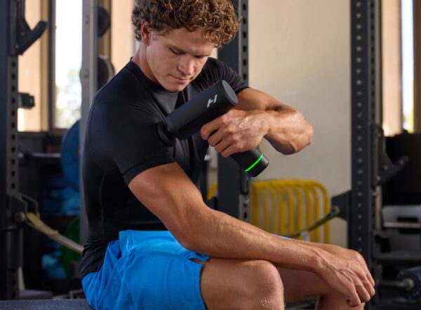 Mężczyzna używa Hypervolt 3 Pro do masażu bicepsa po treningu